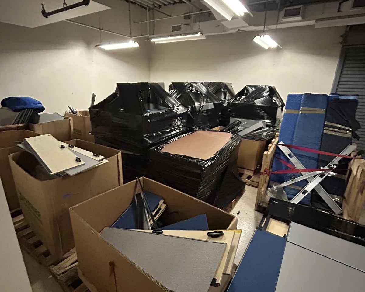 Room packed with furniture and materials before a Premier Office Movers decommissioning